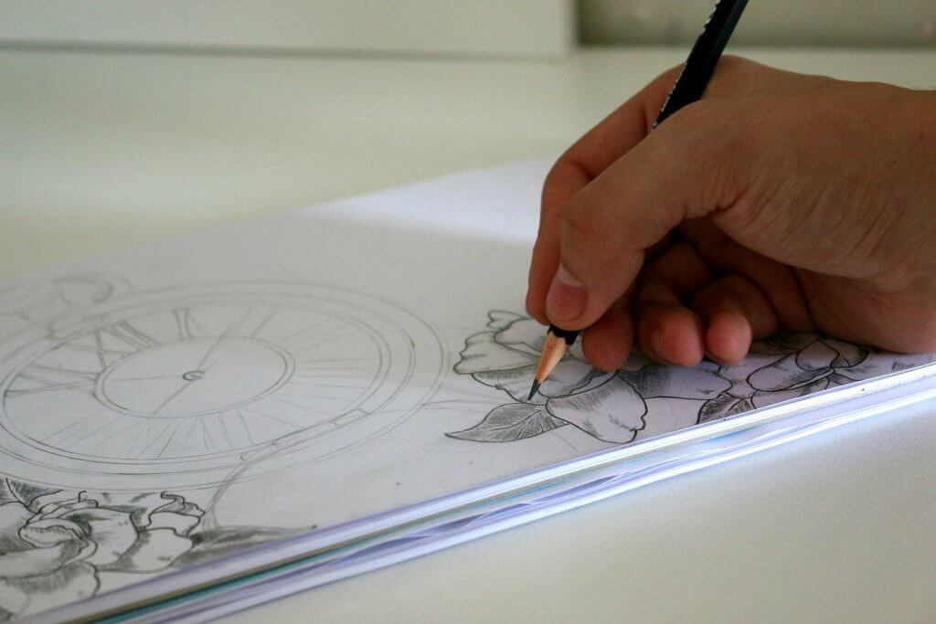 An artist drawing a detailed sketch of a flower