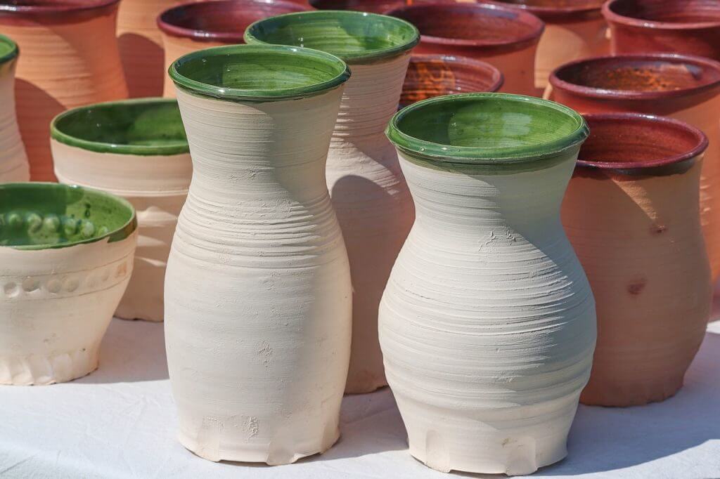Several ceramic vases with a distinctive green glazing around the top rim